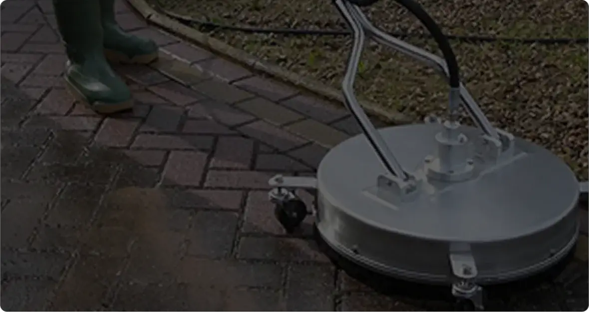 Zoomed in picture of a worker using a surface cleaner to clean pavers